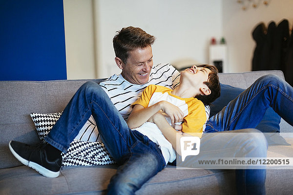 Sorgenfreier Vater und Sohn haben Spaß auf der Couch zu Hause
