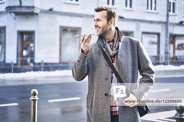 Man talking on the phone on city street during sunny winter day