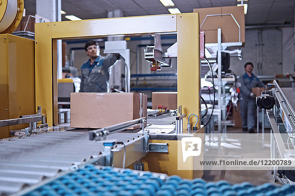 Men at work at conveyor belt in factory