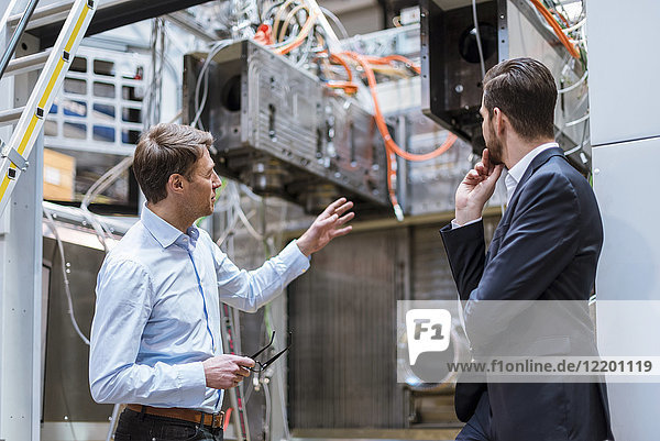 Two businessmen discussing in factory
