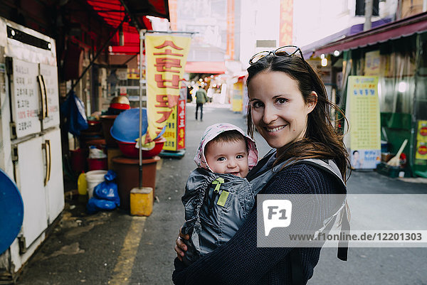 Südkorea  Mutter und Mädchen in einem Tragesitz zu Besuch in Busan