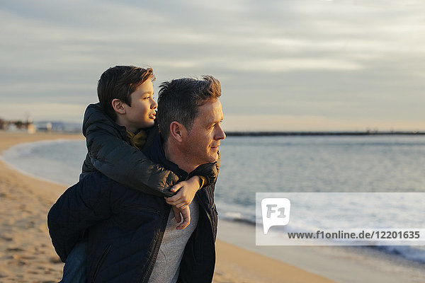 Vater mit Sohn Huckepack am Strand