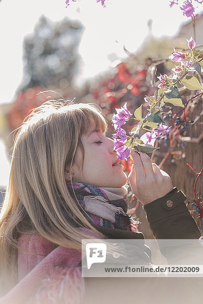 Frau riecht Blumen im Freien