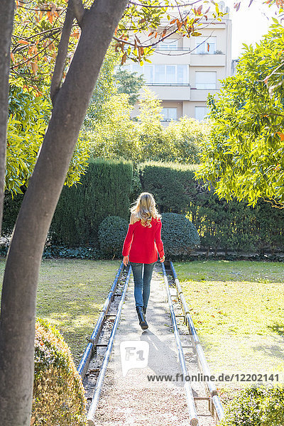 Young woman walking on path in a garden