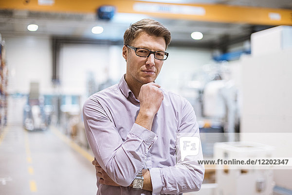 Portrait of serious businessman in factory