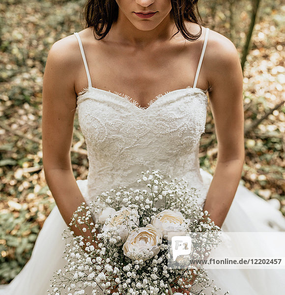 Nahaufnahme der Braut mit Blumenstrauß im Wald