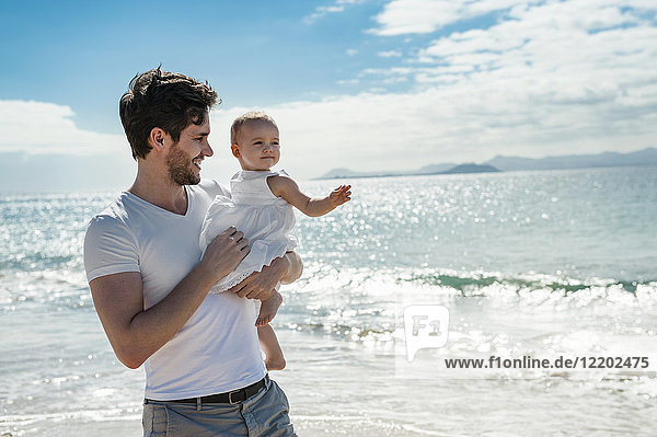 Spanien  Lanzarote  Vater mit seiner kleinen Tochter am Strand