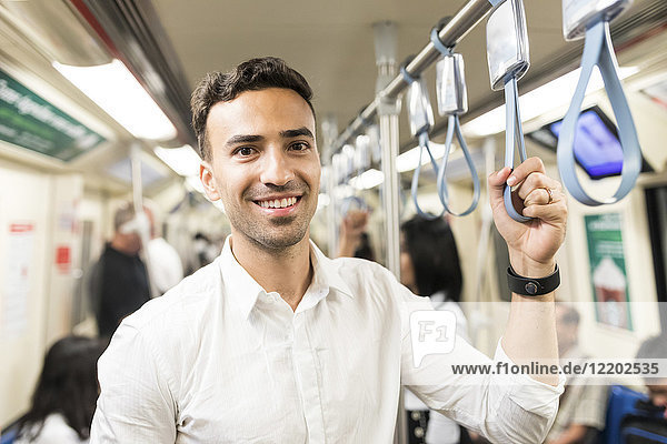 Porträt eines lächelnden Geschäftsmannes in der U-Bahn