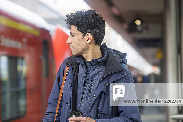Mann mit Rucksack und Kaffee für die Plattform