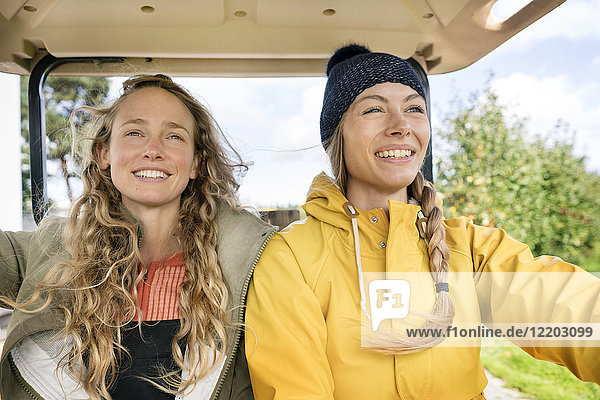 Zwei lächelnde Frauen auf einem Traktor