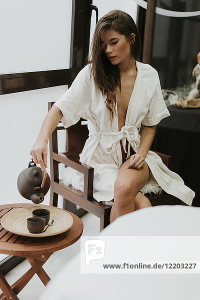Young woman in a spa serving tea