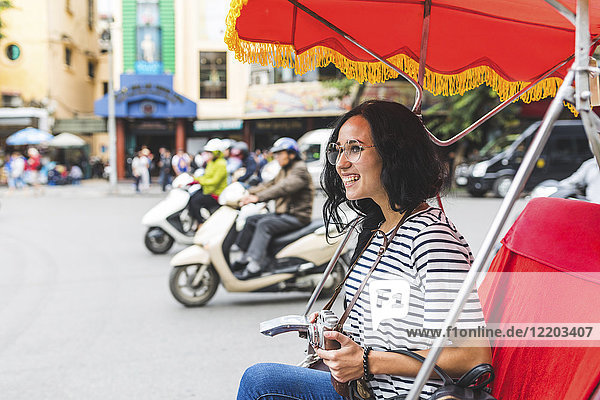 Vietnam  Hanoi  glückliche junge Frau auf einer Rikscha  die die Stadt erkundet.