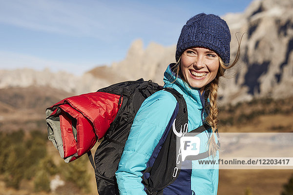Porträt einer glücklichen jungen Frau beim Wandern in den Bergen