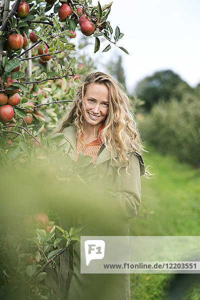Porträt der lächelnden Frau im Apfelgarten