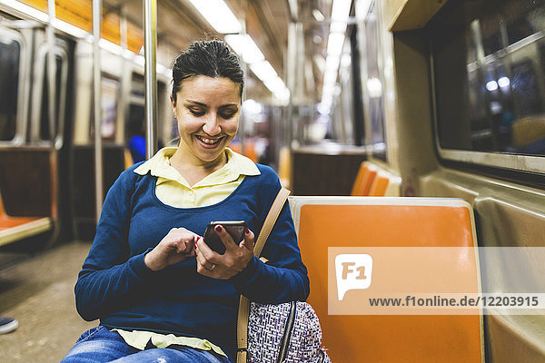 USA  New York  Frau mit Handy in der U-Bahn