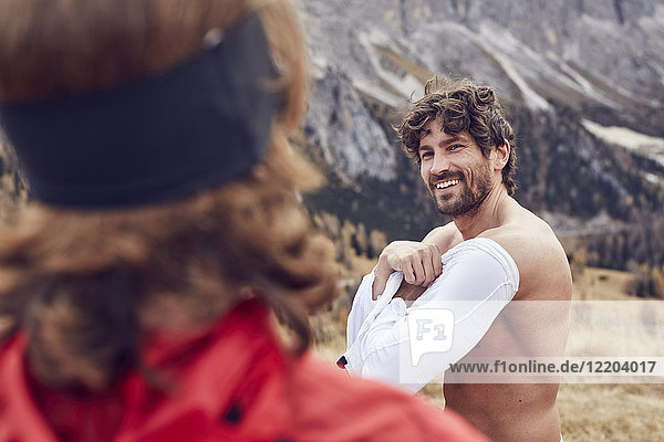 Two trailrunners in the mountains changing shirt