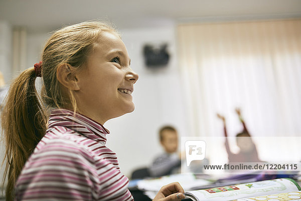 Portrait of smiling schoolgirl in class