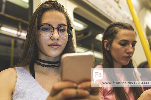 Teenage girl using cell phone in subway