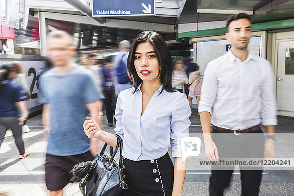 Thailand  Bangkok  Porträt einer Geschäftsfrau inmitten bewegter Menschen in der Stadt