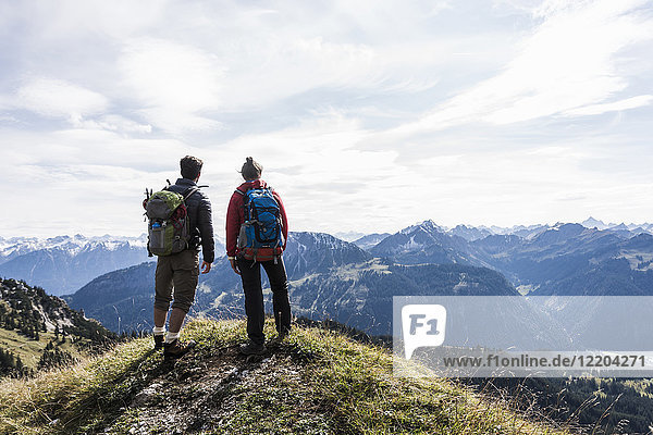 Österreich  Tirol  junges Paar in der Bergwelt stehend mit Blick auf die Landschaft