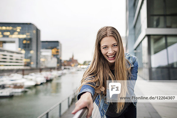 Porträt einer lachenden jungen Frau am Stadthafen