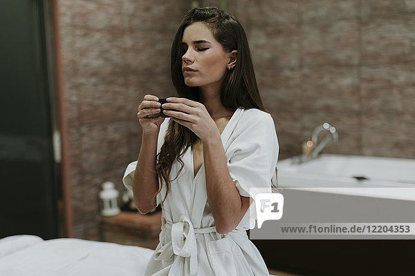 Young woman in a spa enjoying cup of tea