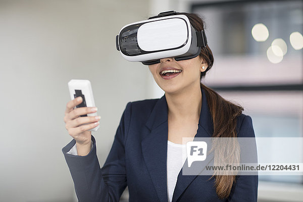 Lächelnde Geschäftsfrau mit VR-Brille im Büro