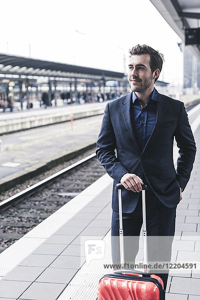 Junger Geschäftsmann wartet am Bahnsteig
