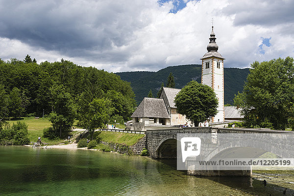 Die Kirche St. Johannes der Täufer und die Steinbrücke am Bohinjer See  Slowenien  Europa