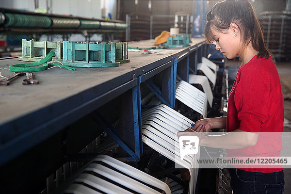 Woman working on silk spinning machine in traditional silk factory Dalat Vietnam Indochina Southeast Asia Asia