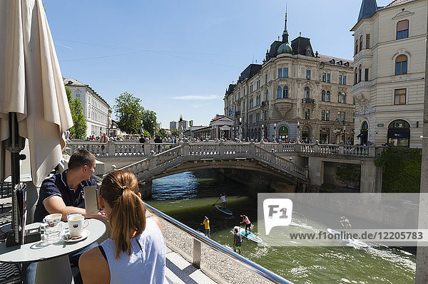 Eine Bar mit Blick auf die Dreifachbrücke über den Fluss Ljubljanica  Ljubljana  Slowenien  Europa