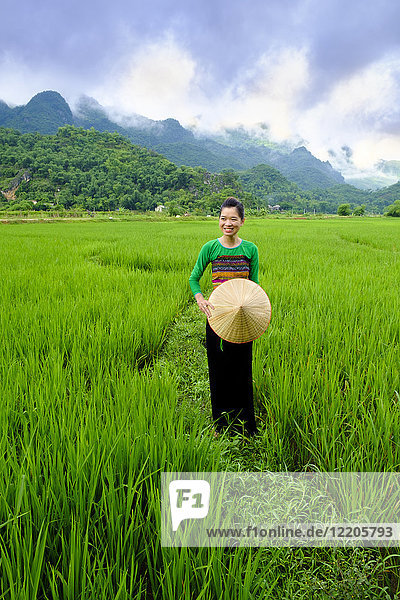 Local White Tai indigenous woman in traditional clothing standing in rice fields Mai Chau Hoa Binh Vietnam Indochina Southeast Asia Asia