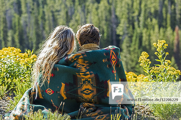 Kaukasisches Paar  eingewickelt in eine Decke  bewundert eine schöne Landschaft