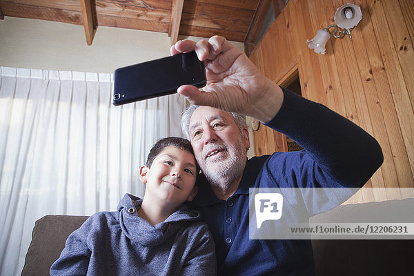 Hispanischer Großvater und Enkel posieren für ein Selfie mit dem Handy