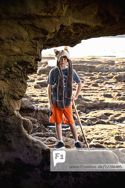 Porträt eines kaukasischen Jungen beim Wandern auf Felsen am Strand