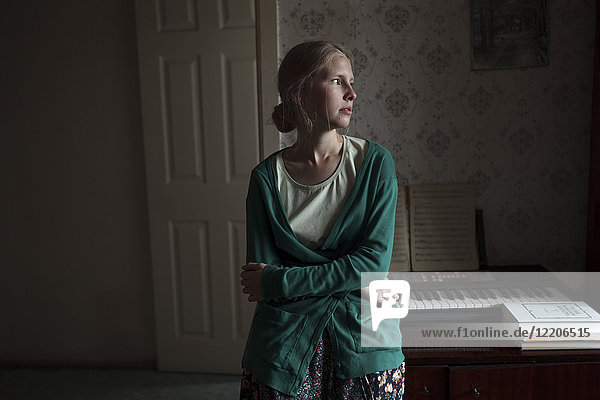 Portrait of pensive Caucasian woman leaning on piano