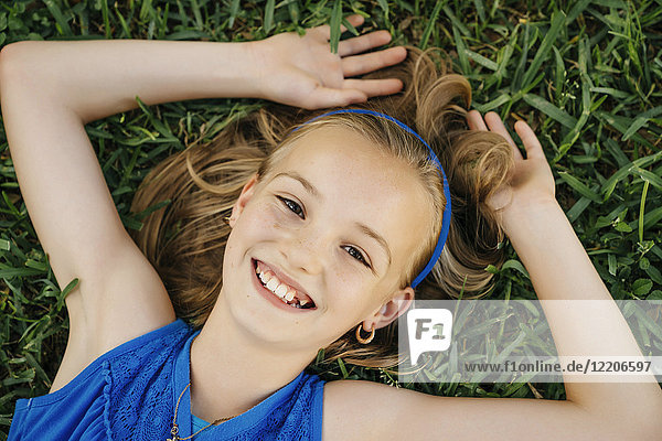 Close up Porträt von lächelnden kaukasischen Mädchen auf Gras liegen