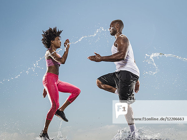 Water splashing on running Black couple