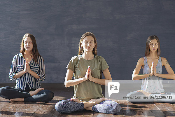 Kaukasische Frauen meditieren im Yoga-Kurs