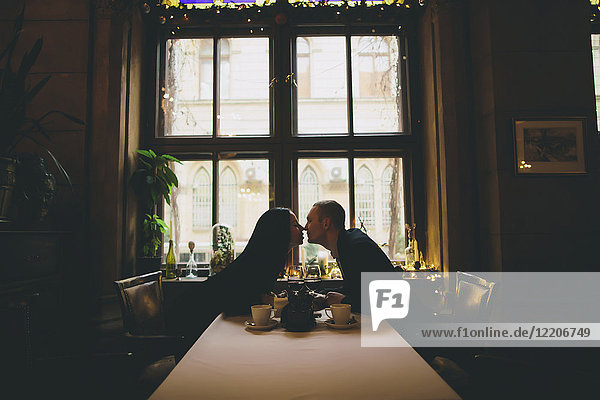 Kaukasisches Paar sitzt am Tisch und reibt sich die Nasen
