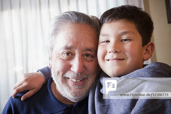 Hispanic grandfather and grandson hugging