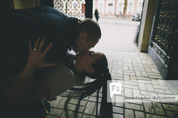Caucasian man dipping and kissing woman