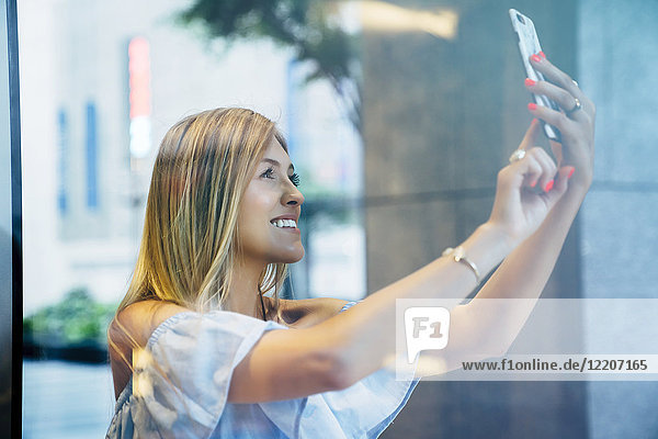 Smiling Caucasian woman posing for cell phone selfie