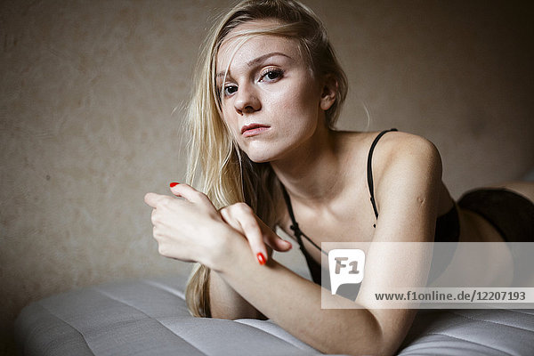 Close up of serious Caucasian woman resting on bed