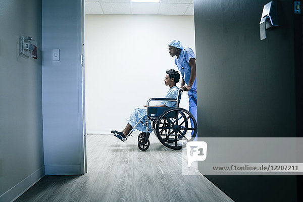 Nurse pushing boy in wheelchair