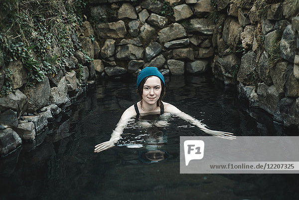 Porträt einer lächelnden kaukasischen Frau mit Strumpfmütze beim Schwimmen