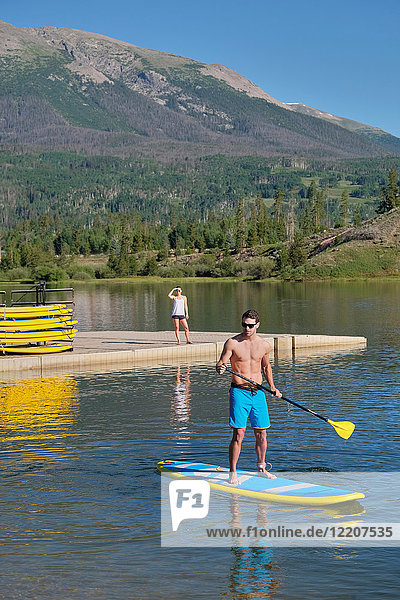 Man stand up paddleboarding on lake  Frisco  Colorado  USA