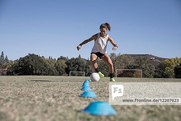 Frau dribbelt Fussball