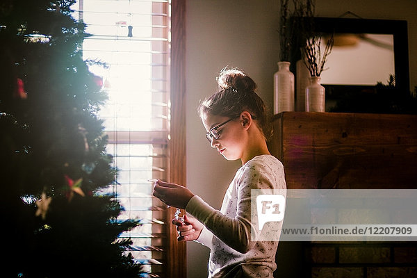 Girl putting up Christmas decorations