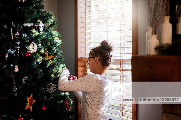Girl putting up Christmas decorations